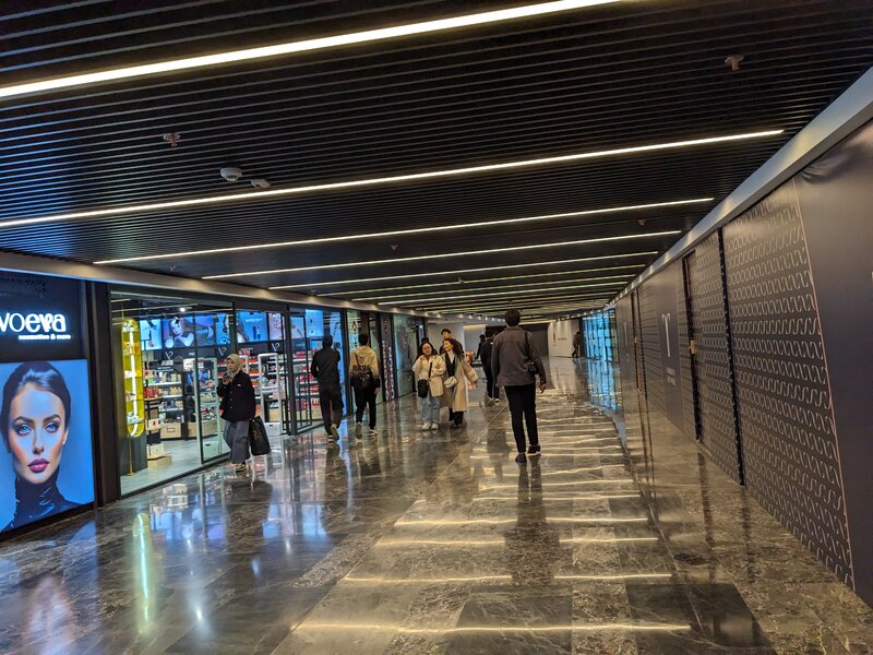 A tunnel with storefronts, leading to the shopping mall