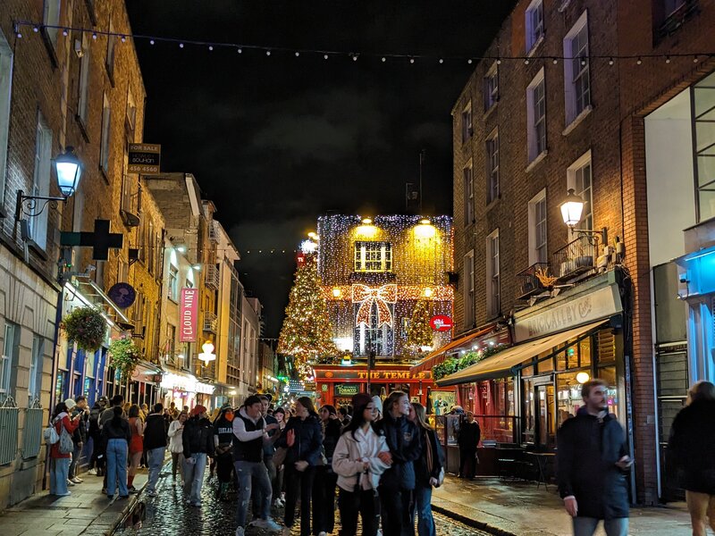 A busy cobblestone street with Christmas decorations