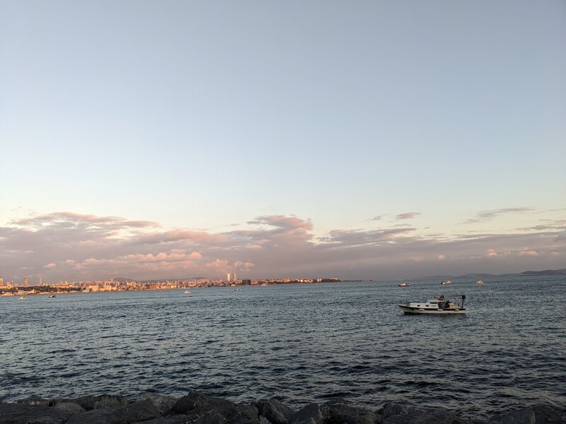 A strait in the evening with a small boat passing by